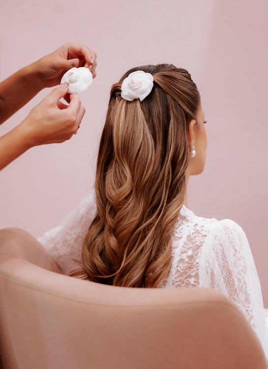Finalização de penteado de noiva com flores brancas